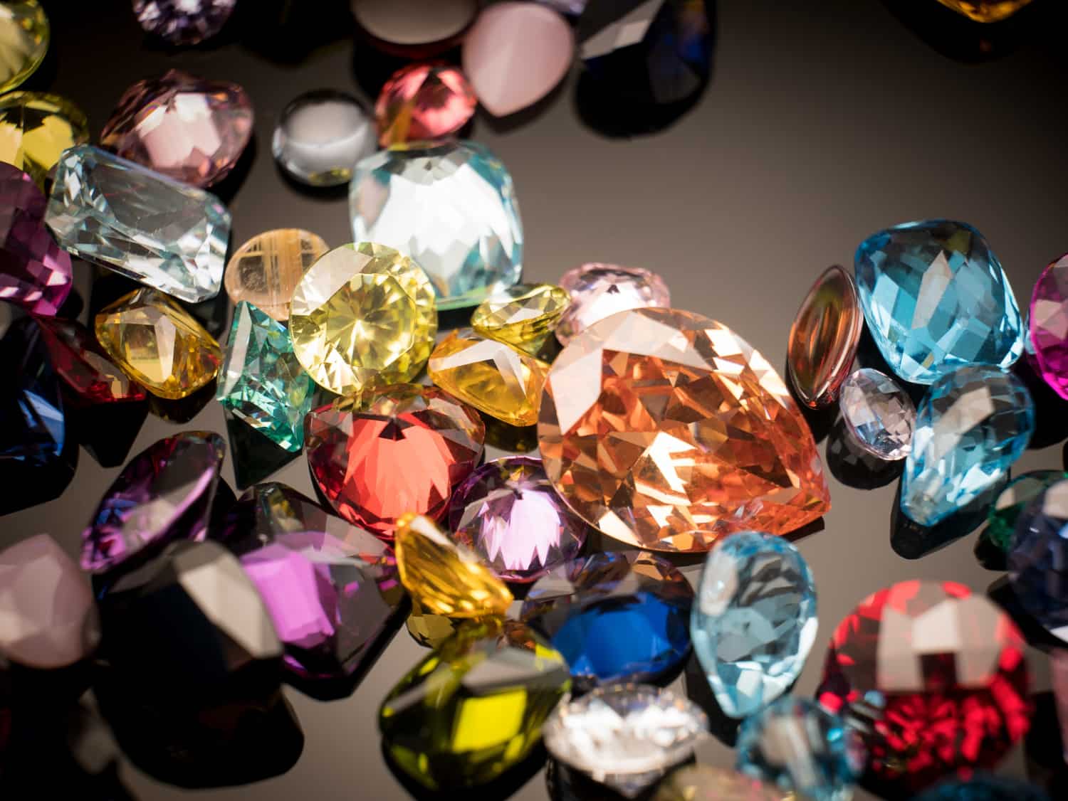 Diverse collection of colorful, faceted gemstones for rings